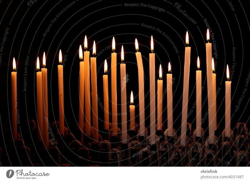 Kerzen in Reihe vor dunklem Hintergrund kerzen licht schatten dunkelheit leuchten helligkeit kirche gottesdienst angst trauer christentum jesus flamme
