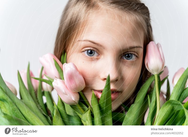 Kleine schöne glückliche Mädchen hält Strauß von rosa, grünen Tulpen in den Händen. Blumenstrauß, Glückwünsche zum Urlaub der Mutter, Valentinstag. Internationaler Frauentag, 8. März.Frühling, Sommerzeit Konzept