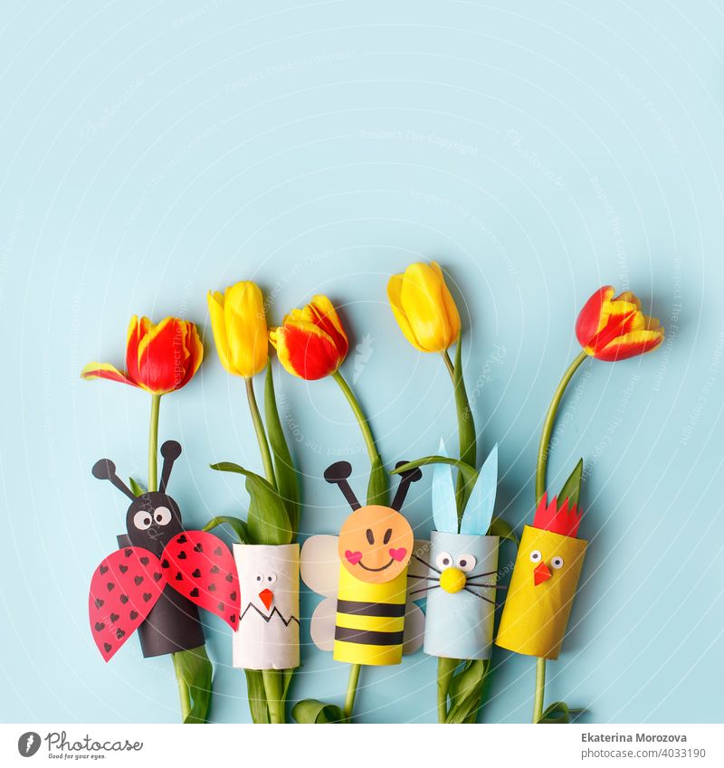 Frohe Ostern Frühling Spielzeug Sammlung und frische Blumen auf blauem Hintergrund, Kinder Urlaub Partei Konzept Hintergrund. Papier Handwerk, DIY. kreative Idee von Toilettenpapier. wiederverwenden, recyceln