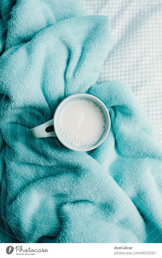 Eine Tasse Milch über einer kuscheligen Decke Stimmung Komfort heimwärts Innenbereich weich warm lebend Schreibstift planen Buch Teppich copyspace Leben