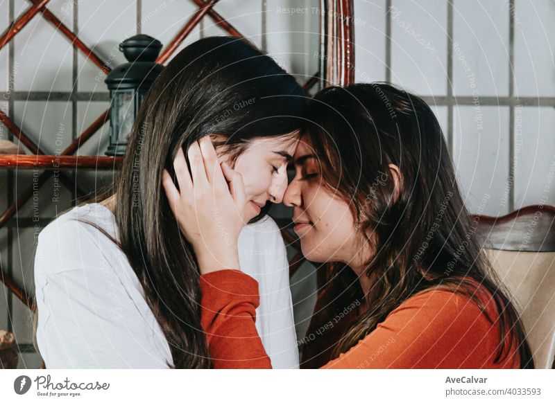 Ein lesbisches Paar über zu küssen einander auf eine schöne Aufnahme in einer modernen Wohnung anhänglich Antwort an Kuscheln umarmend Freunde Mädchen