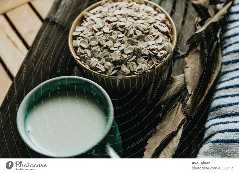 Ein Frühstück aus einer Tasse Hafermilch mit Hafersamen auf einem Holzbrett melken Lebensmittel Gesundheit Korn organisch Samen Ernährung Müsli weiß natürlich