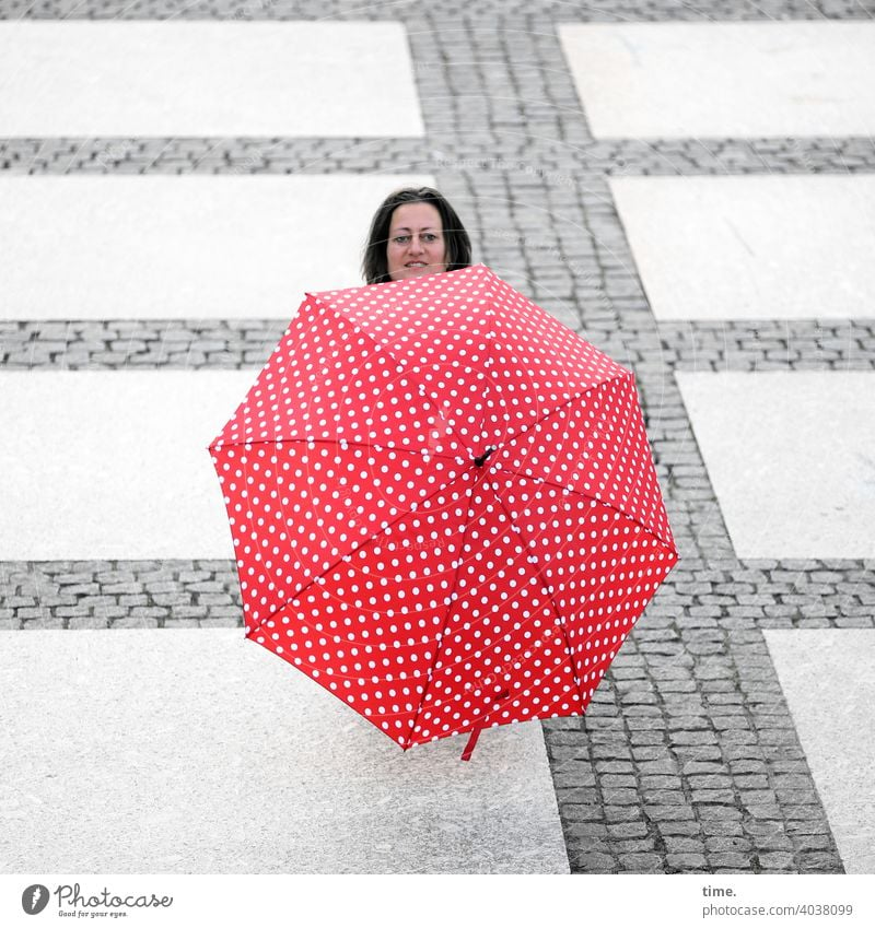 Frau hinter Schirm voraus Kopf verstecken Platz Steinweg neugierig lächeln linien rot skurril Sonnenschirm regenschirm