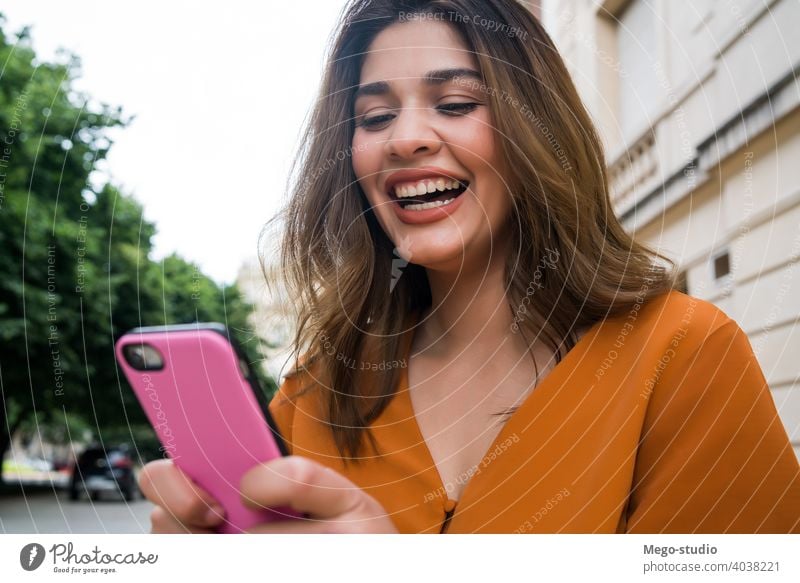 Junge Frau benutzt ihr Mobiltelefon. jung Mobile Telefon im Freien Großstadt Smartphone Menschen urban klug Funktelefon Text SMS Nachricht Erwachsener online