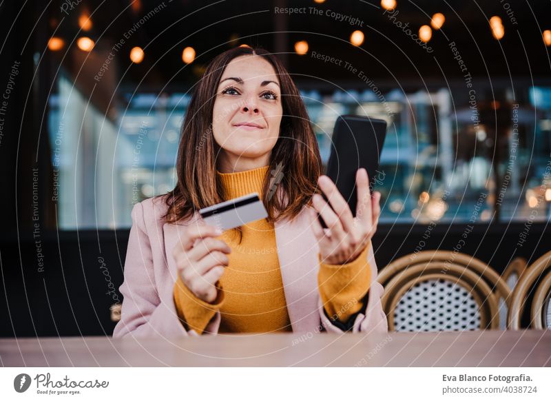 glückliche kaukasische Frau in Terrasse mit Handy-Gerät und Kreditkarte für Online-Shopping. Technologie und Lifestyle-Konzept kaufen Kaukasier