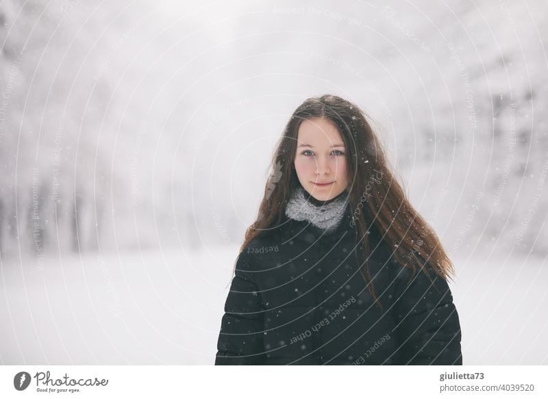 Porträt eines langhaarigen Teenager Mädchens bei Schneefall im Winter weiß feminin verschneit 13-18 Jahre schön natürlich Blick Hintergrund neutral