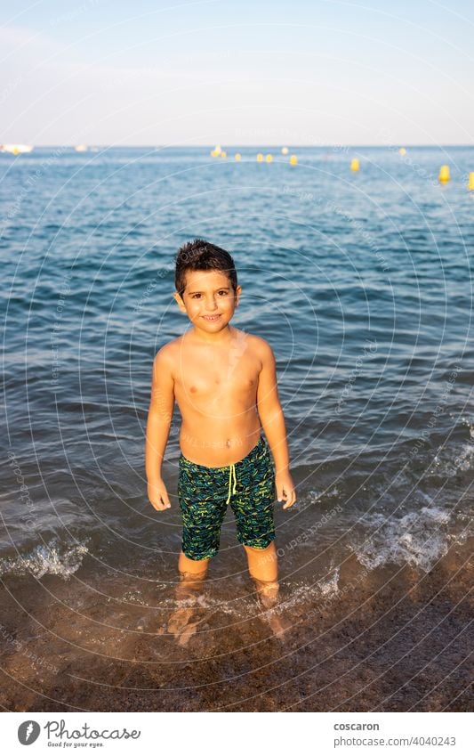 Netter Junge am Ufer des Strandes ins Meer schön blau heiter Kind Kindheit Küste Küstenlinie niedlich genießend exotisch schäumen Spaß Fröhlichkeit Glück