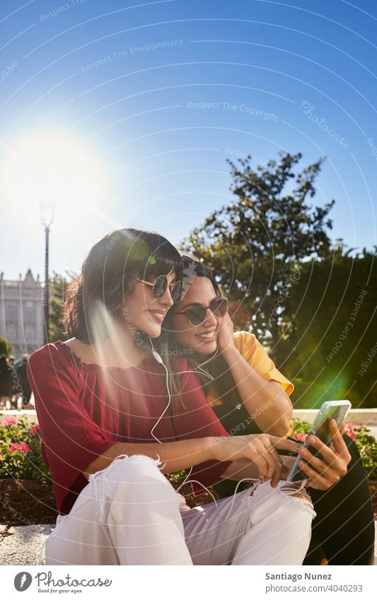Zwei Teenager-Mädchen schauen auf das Telefon. Madrid jung Menschen Freundschaft Freunde Lifestyle schön Spaß Glück Zusammensein Freizeit Frau Lächeln