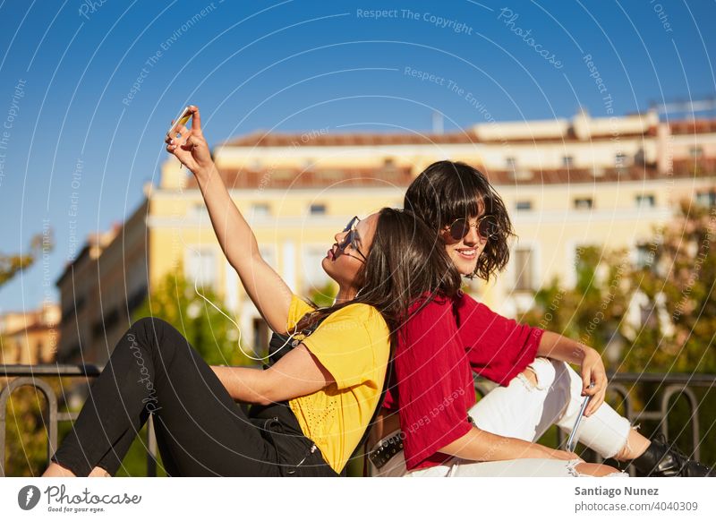 Zwei Teenager-Mädchen sitzen und nehmen Selfie. Madrid jung Menschen Freundschaft Freunde Lifestyle schön Spaß Glück Zusammensein Freizeit Frau Lächeln