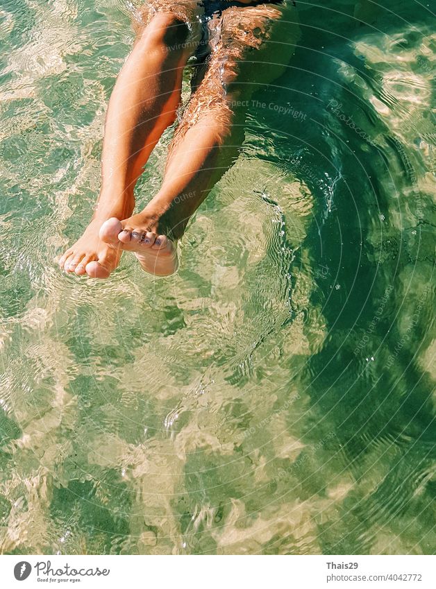 Glückliches Mädchen haben Schwimmen und Spaß haben im Meer Ozean Wasser. Close up nackten Beine. Menschen im Wassersport, extreme Aktivität im Sommer Strandurlaub. Wassersport Hintergrund
