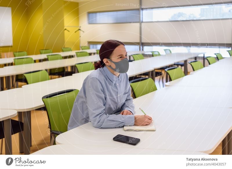 Frau mit Gesichtsmaske in leerem Klassenzimmer Schüler Klassenraum Bildung Lernen Schule studierend zurück zur Schule Universität neue Normale Person
