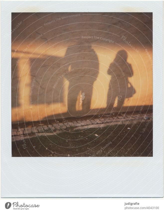 Schatten eines Paares auf Hauswand auf Polaroid Wand Licht Straße Fassade Mauer Kopfsteinplaster