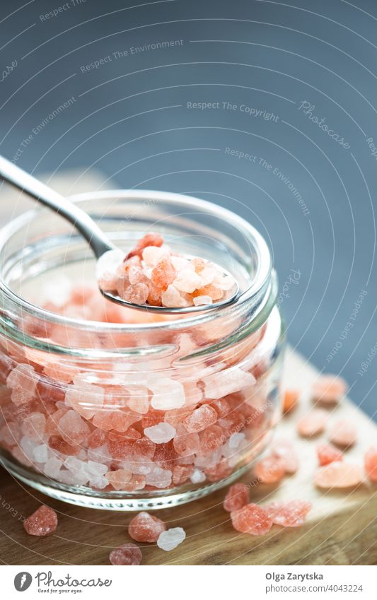 Rosa Himalaya-Salz im Glasgefäß. rosa himalajanisch Kristalle Felsen Löffel Therapie Tisch Gewürz Mineral Lebensmittel Natrium natürlich Hintergrund Nahaufnahme