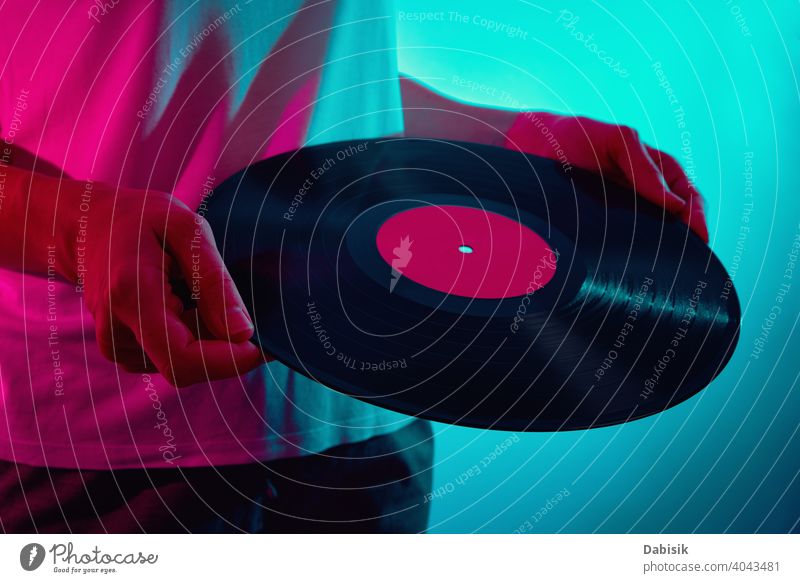 Frau hält Retro-Vinylscheibe mit Neonlicht Scheibe Musik neonfarbig retro altehrwürdig Aufzeichnen Klang Lamelle Album Entertainment Audio schwarz stereo dj