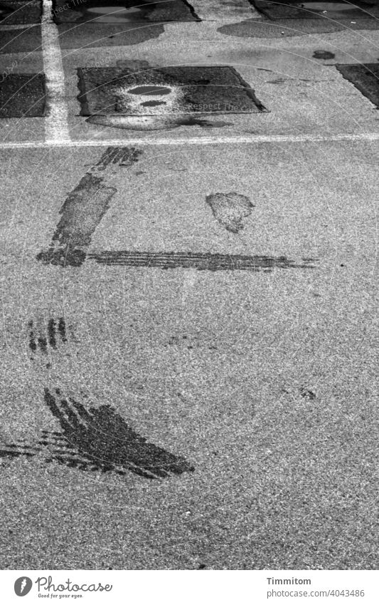 Auf geht's... und dabei Spuren hinterlassen Parkplatz Pfütze Nässe Reifen Reifenspuren Straße nass Menschenleer Asphalt Schwarzweißfoto grau schwarz