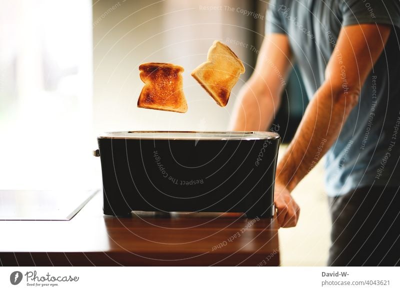 Frühstück vorbereiten -  das Toast ist fertig springt Toaster frühstücken schnell Zeitdruck Toastbrot Küche Ernährung Kohlenhydrate Mann Essen