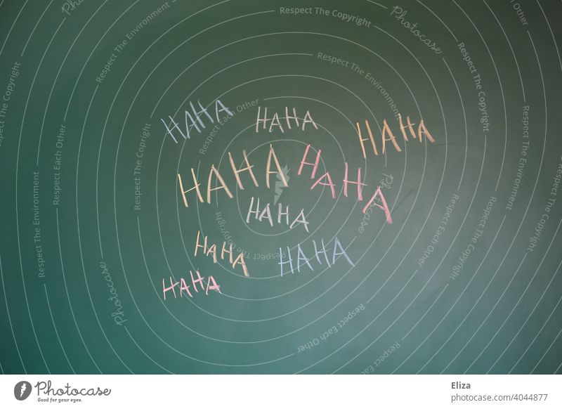 Haha in mehreren Farben auf eine Tafel geschrieben. Konzept lachen, lustig und Mobbing. auslachen lustig machen witzig bunt mobben Witz Wort Humor