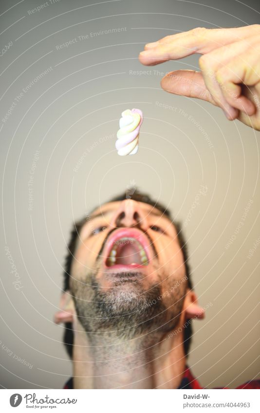 Süßigkeiten essen - Zucker pur Kohlenhydrate ungesund Ernährung Mund Mann Dickmacher lecker Sucht Bonbon Hunger naschen
