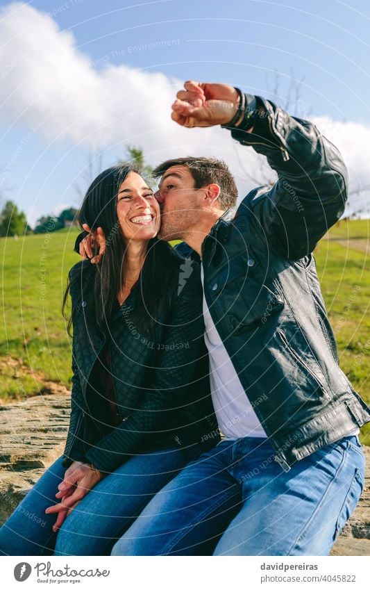 Pärchen, das sich küsst und ein Selfie mit einer Smartwatch macht Paar Küssen unter Bild smartwatch Spaß Glück Mann zuschauen tragbar Technik & Technologie