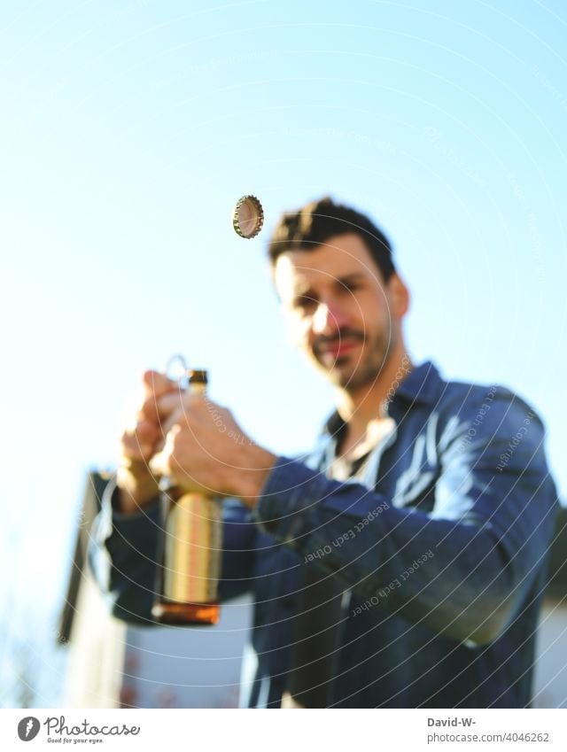 Mann öffnet eine Bierflasche Alkohol öffnen Kronkorken fliegen Flaschenöffner gutes Wetter Sommer gesellschaft Getränk trinken Feste & Feiern Vatertag