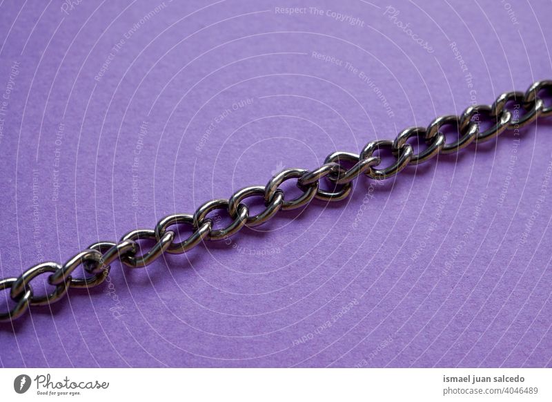 Metallkette auf dem lila Hintergrund anketten metallisch Objekt Stillleben purpur texturiert sehr wenige minimalistisch Kettenglied Link Stahl Industrie
