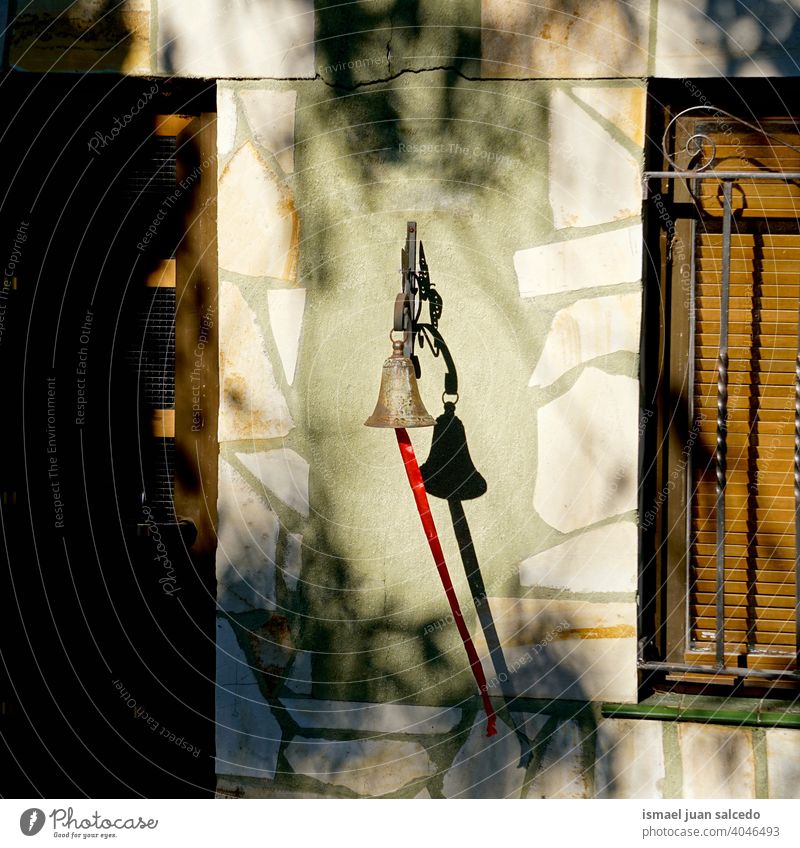 Glocke an der Wand des Hauses Klingel metallisch Schatten Tür Fenster Farbfoto Fassade Menschenleer Außenaufnahme Architektur Eingangstür Häusliches Leben