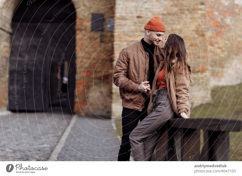 Schöne Tourist Paar in der Liebe zu Fuß auf der Straße zusammen. Happy Young Man And Smiling Woman Walking Around Old Town Streets, Blick auf Architektur. Reise-Konzept.