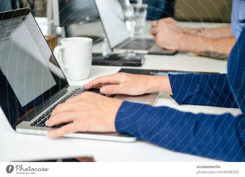 Mitarbeiter arbeitem am Laptop im Büro Sitzen Notebook modern Arbeitsbereich Schreibtisch Cyberspace Desktop Arbeitsplatz Keyboard Computer Internet arbeiten
