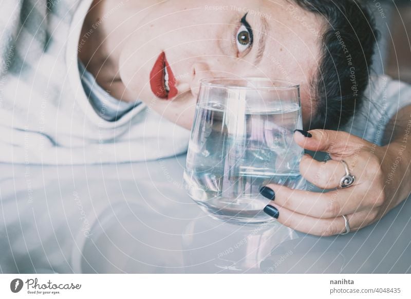 Porträt einer jungen Frau, verdeckt durch ein Glas mit einem transparenten Getränk Depression blau traurig mental Gesundheit Psychologie Traurigkeit depressiv