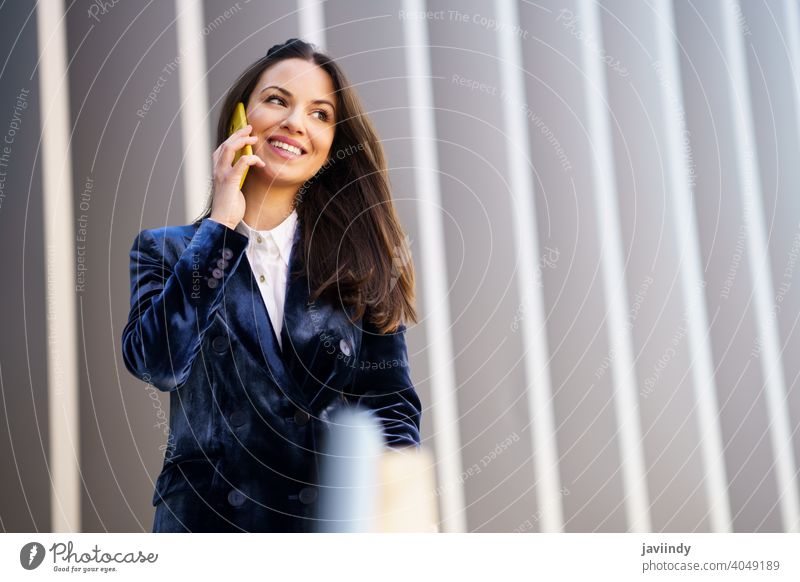 Business-Frau im blauen Anzug mit Smartphone in einem Bürogebäude. Geschäftsfrau Mädchen klug Telefon Person Gerät Lifestyle urban Hintergrund Dame elegant