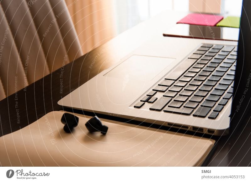Der Arbeitsplatz einer Person zu Hause: Laptop, Smartphone und Kopfhörer. Konzeption der Telearbeit von zu Hause aus. Arbeitsbereich heimwärts Büro Business