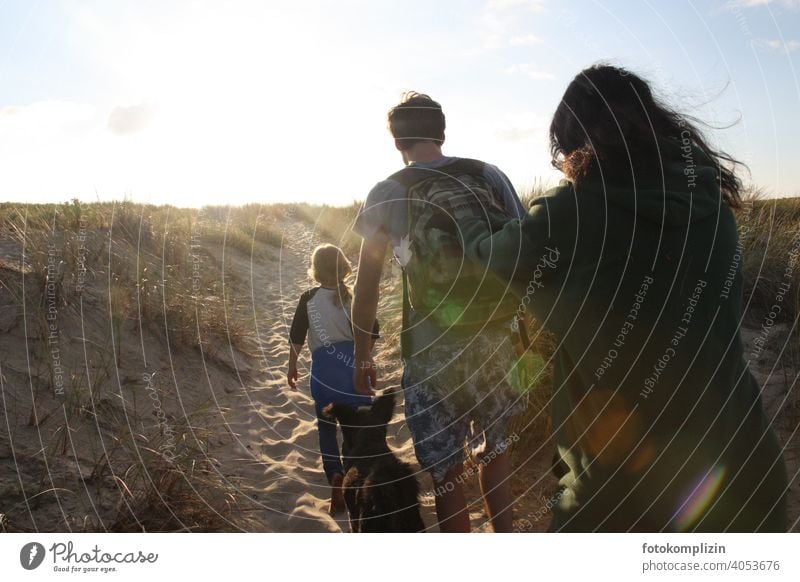 Jugendliche mit Kind und Hund auf dem Weg über die Düne zum Strand Sanddüne Strandspaziergang Sommerurlaub Ferien & Urlaub & Reisen Familienurlaub Zusammensein