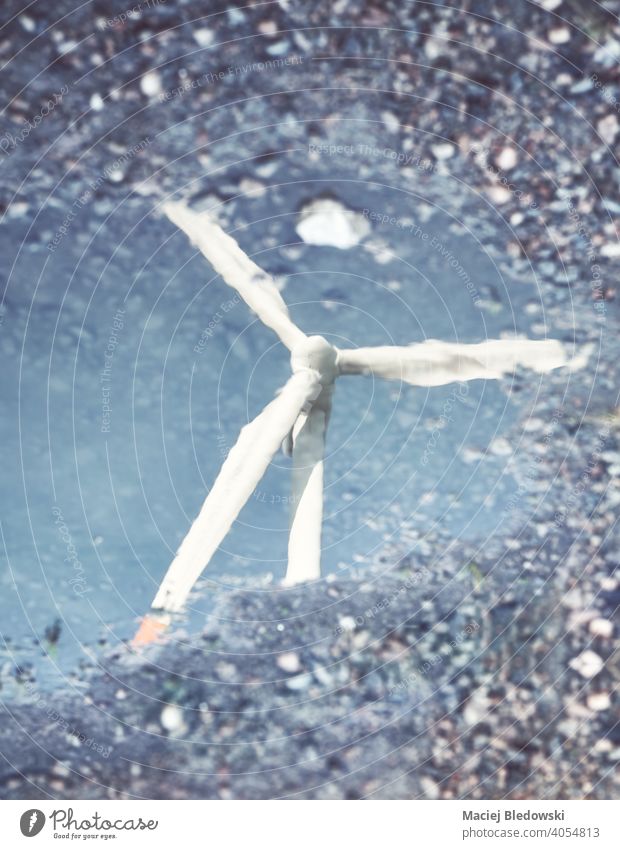 Unscharfes Bild einer Windmühlenturbine Reflexion in einer Pfütze, abstrakte konzeptionelle Hintergrund. Turbine Wasser Konzept verschwommen Umwelt