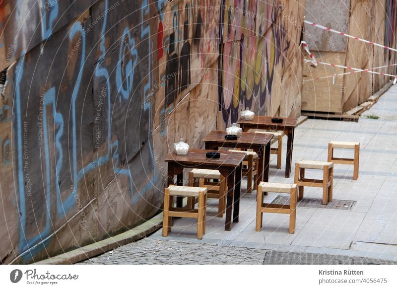 café terrasse in istanbul tische hocker restaurant aschenbecher zucker zuckerdosen draußen sitzen wand graffiti absperrband gastronomie türkisch türkei