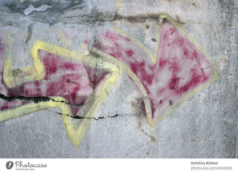 verblasster graffiti pfeil wand mauer streetart besprüht kunst detail richtung verblichen farbe hintergrund kontur muster risse abstrakt