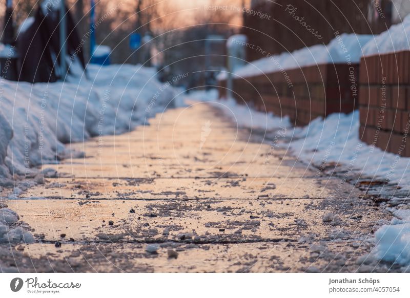 Gehweg im Winter bei Sonnenuntergang Bodenplatten Bürgersteig Dämmerung Fußweg Schnee Winterdienst gefroren geräumt geschippt glatt kalt laufen schneefrei
