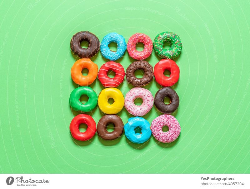 Donuts mit Zuckerguss Ansicht von oben. Mehrfarbige Donuts auf einem grünen Hintergrund. obere Ansicht ausgerichtet sortiert gebacken blau Kuchen Schokolade