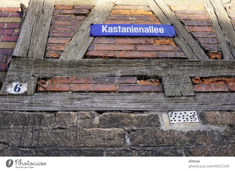 An einem alten Fachwerkhaus befindet sich ein Straßenschild "Kastanienallee" und ein Schild mit der Hausnummer 6 / ländliches Wohnen / Froschperspektive wohnen