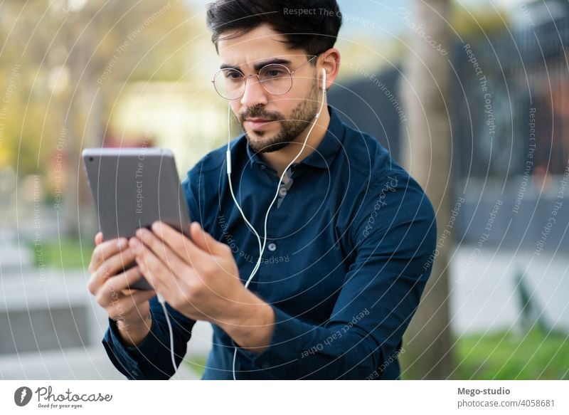 Junger Mann bei einem Videoanruf auf einem digitalen Tablet im Freien. jung Tablette Technik & Technologie Mobile arbeiten sozial Netzwerk Touchscreen außerhalb