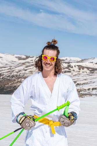 Skifahrer als Karateka verkleidet an einer Skistation Sport Aktion aktiv Aktivität Abenteuer künstlerisch schön kalt cool Tracht bergab extrem Extremskifahrer