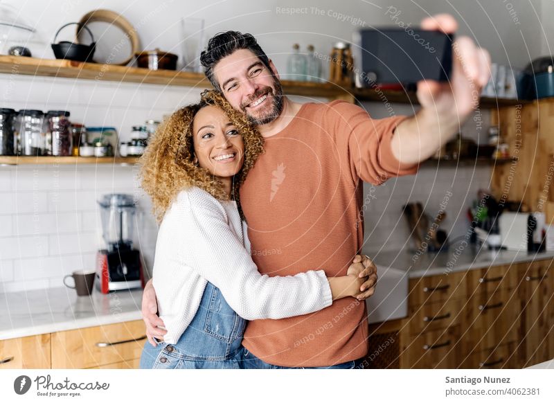 Paar nimmt ein Selfie stehend in der Küche. Lebensmitte Liebe Essen zubereiten heimwärts gemütlich Kaukasier Partnerschaft vorbereitend Frau Glück Person Herd