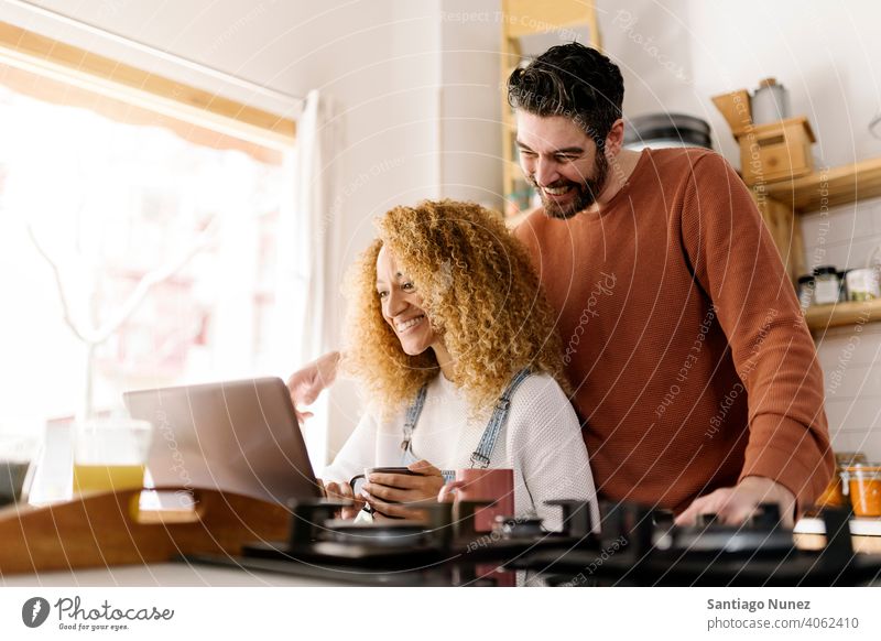 Ehepaar schaut in der Küche auf einen Laptop. Lebensmitte Paar Liebe Essen zubereiten heimwärts gemütlich Kaukasier Partnerschaft vorbereitend Frau Glück Person
