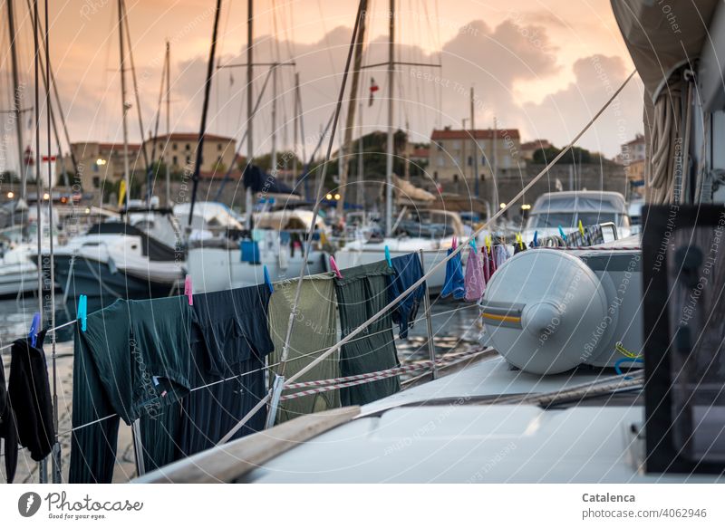 Waschtag, Wäsche hängt zum trocknen an der Reling einer Segelyacht in der Marina, im Hintergrund Gebäude Yachthafen Maste Segelboote Wäsche waschen Wäscheleine