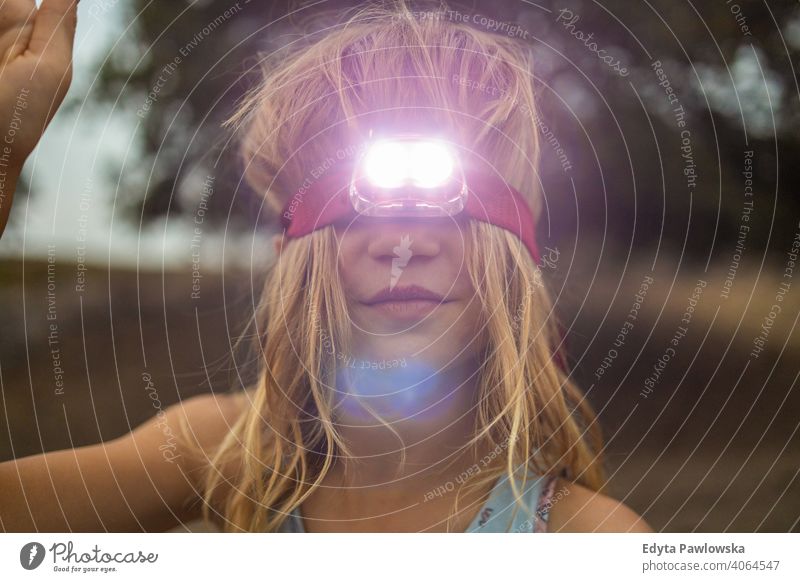Mädchen mit Kopftaschenlampe im Freien Spaß Menschen Sommer Camping retro altehrwürdig Taschenlampe reisen Abenteuer Kindheit Stirnlampe Scheinwerfer Abend