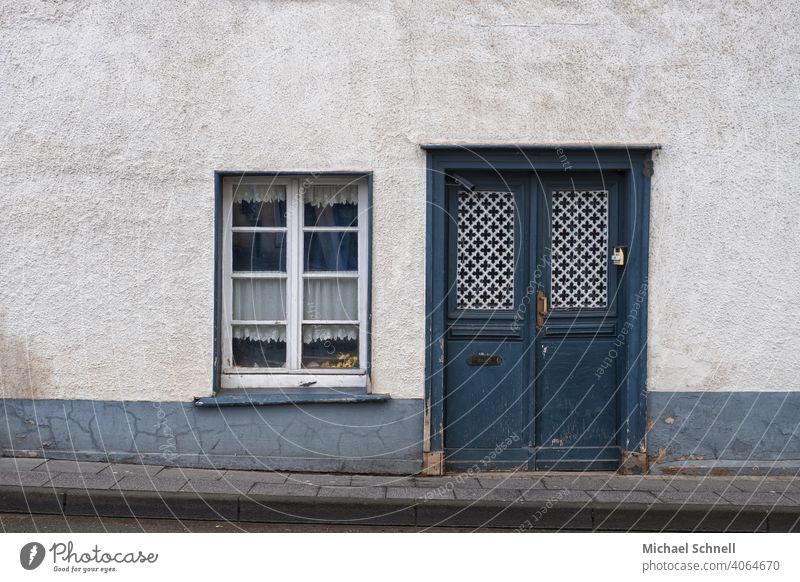 Eingang und Fenster eines alten Hauses Gebäude Hausfassade Eingangstür blau Holztür Außenaufnahme Menschenleer geschlossen