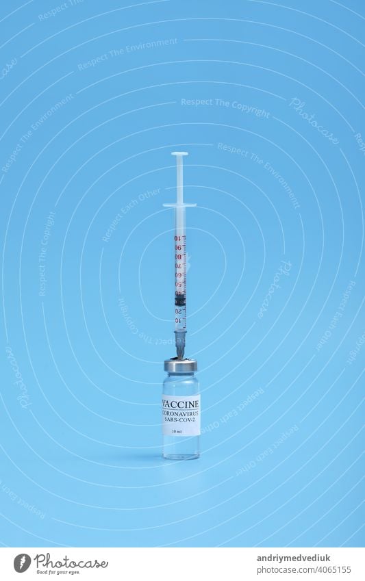 Medizin Flasche mit Coronavirus-Impfstoff Covid-19. Medizinische Glasfläschchen und Spritze für die Impfung. Flüssiger Impfstoff im Labor, Krankenhaus oder Apotheke Konzept isoliert auf blauem Hintergrund