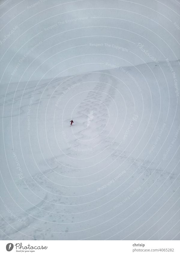 einsamer Schifahrer im Pulverschnee Schnee Farbfoto Abfahrt abwärts schwungvoll Schlangenlinie Detailaufnahme Bogen wallpaper Bild bedrohlich Kurve Skipiste