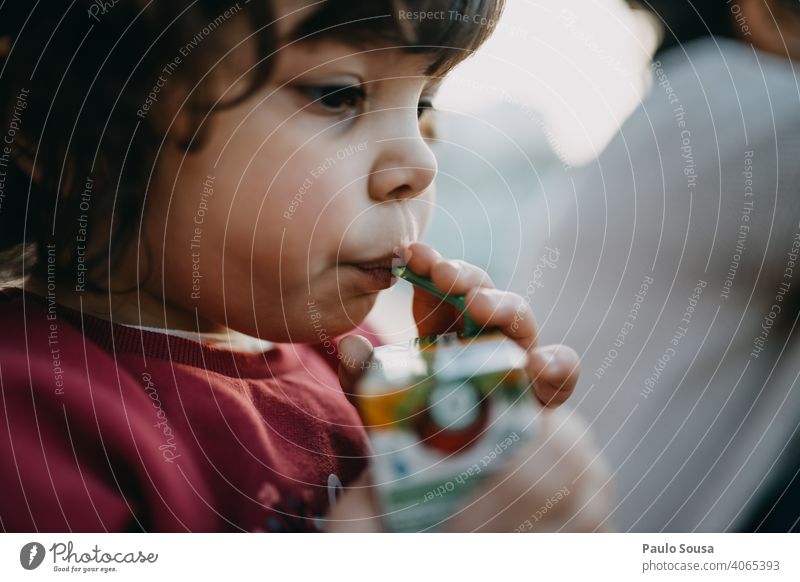 Kind trinkt Saft aus Strohhalm 1-3 Jahre Kaukasier Mädchen authentisch trinken Farbfoto Kindheit Mensch Außenaufnahme Kleinkind Freude Lifestyle Fröhlichkeit