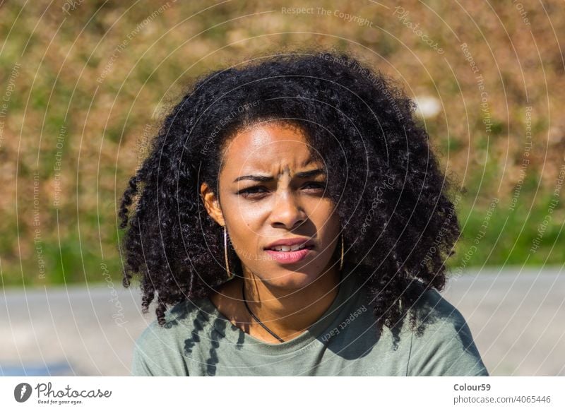 Huebsche dunkelhaeutige Frau Afroamerikanerin Afrikanerin nachdenklich Portrait Gesicht schauen Blick charmant attraktiv Haare schwarz farbig Emotion schön