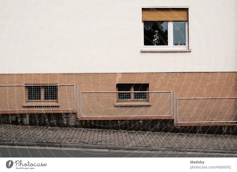 Bürgersteig mit Zaun auf einer abfallenden Straße und Fassade eines Wohnhaus mit Fenster und Rollladen in Wettenberg Krofdorf-Gleiberg bei Gießen in Hessen Haus